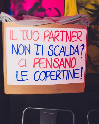 Cartello scritto a mano: «Il tuo partner non ti scalda? Ci pensano le copertine!»