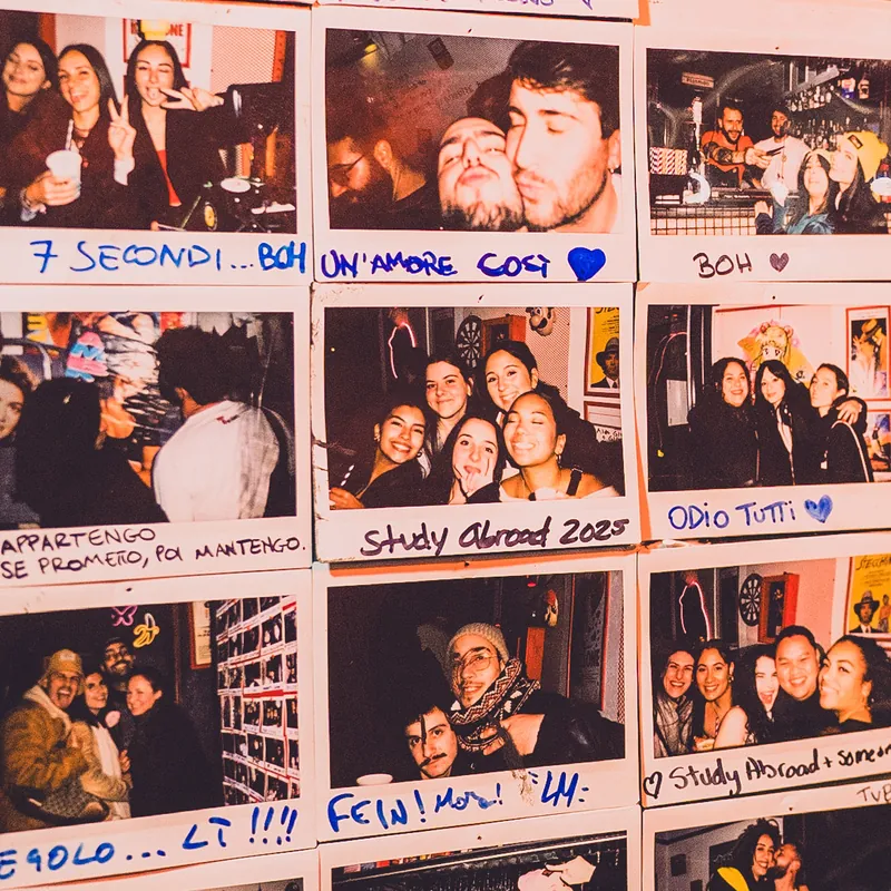 Dettaglio della parete Polaroid con dediche come «7 secondi... boh» e «Study Abroad 2025»