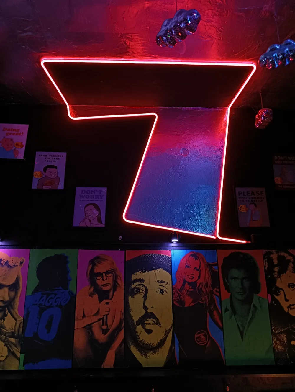 Grande 7 rosso al neon sulla parete argentata del 7COINS
